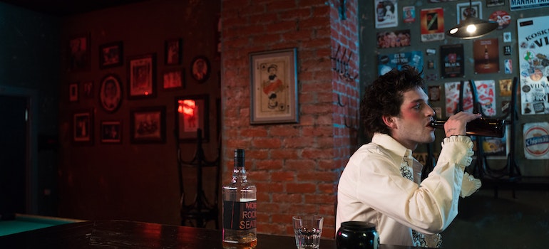 Man drinking in a bar because he believed in myths of alcohol relapse.