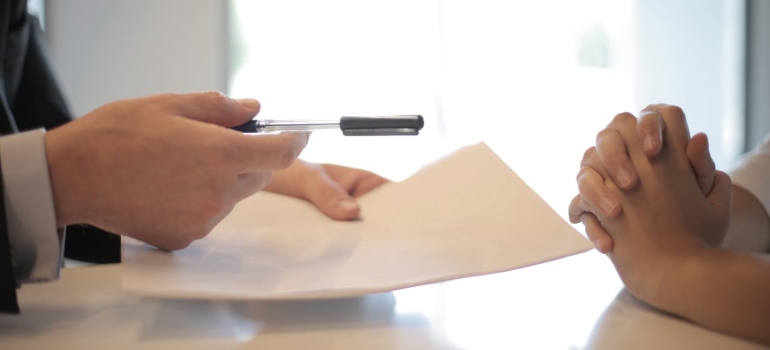 a man handing a pen to another men